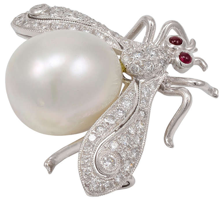 Charming brilliant figural bug brooch in 18k white gold. The body is composed of a large South Sea pearl; cabochon ruby eyes; diamond encrusted wings.
A sparkling cheerful good luck bug .