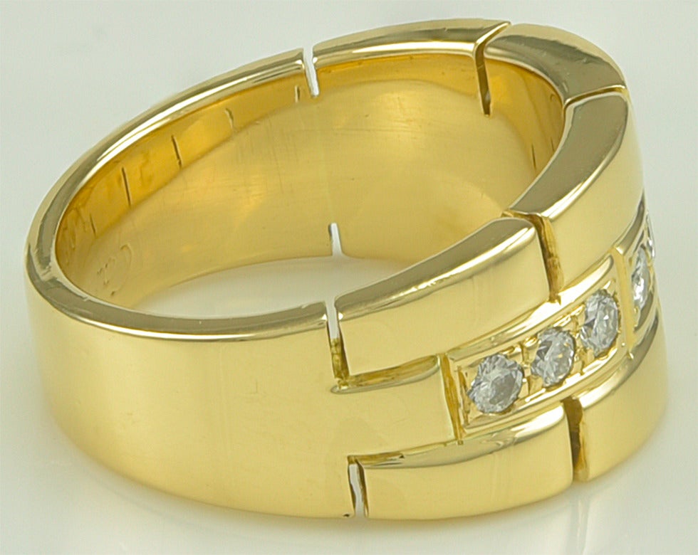 Very attractive wide band, made signed and numbered by Cartier. 
18K yellow gold, set with a center row of sparkling diamonds. 1/2