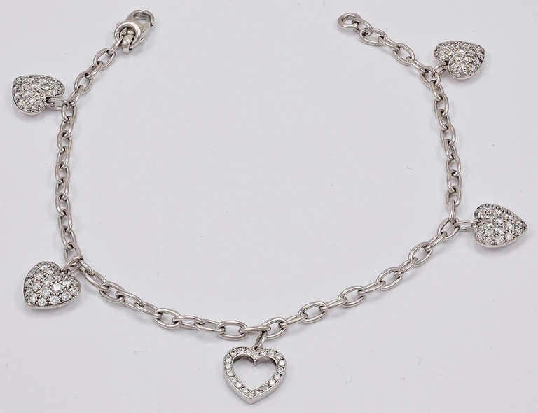 Beautiful and feminine heart charm bracelet.Made and signed by Tiffany & Co.
Set in platinium four soild hearts, completely pave set with diamonds, with one diamond open heart drop in the center. Shimmers and glows on the skin.
A perfect romantic