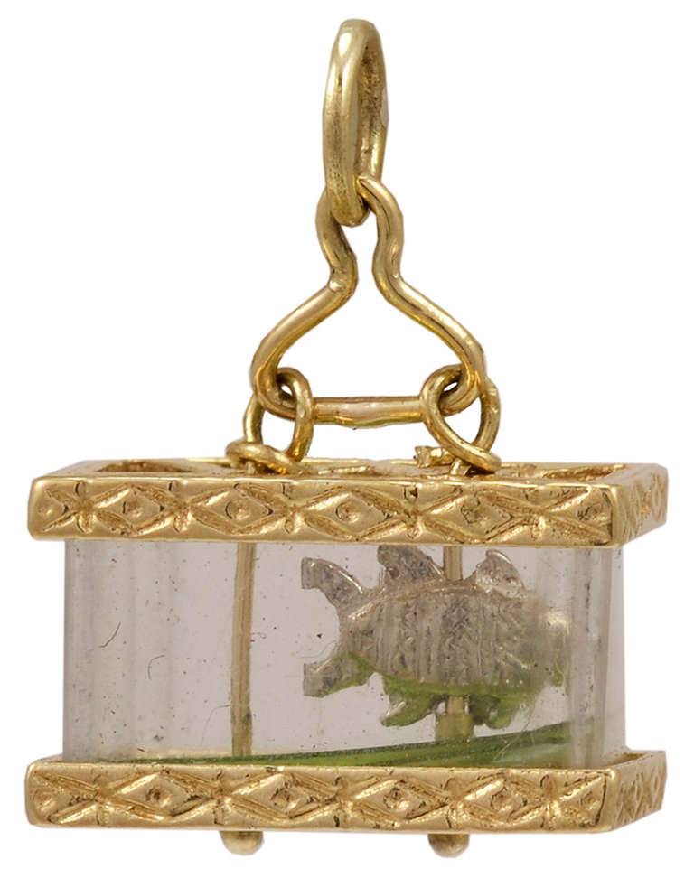This is a fabulous, unusual, adorable piece of jewelry.
The subject is a 14K gold well-detailed fish, swimming  in a crystal and 14K gold embossed fish tank.
A most rare and appealing charm.