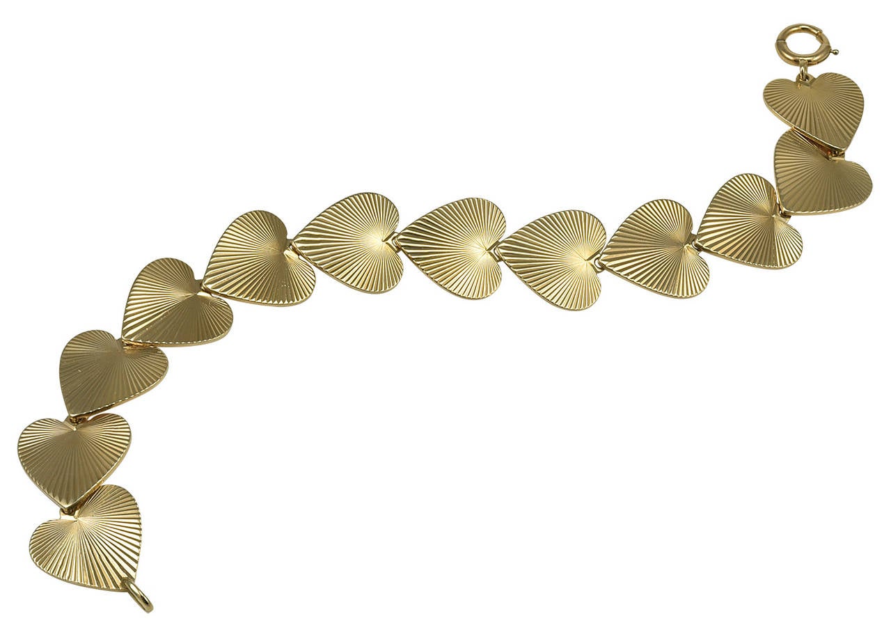 Lovely figural heart  link bracelet. Bright cut engine- turned engraved links, set in 14k yellow gold. Flexible. 7 1/4