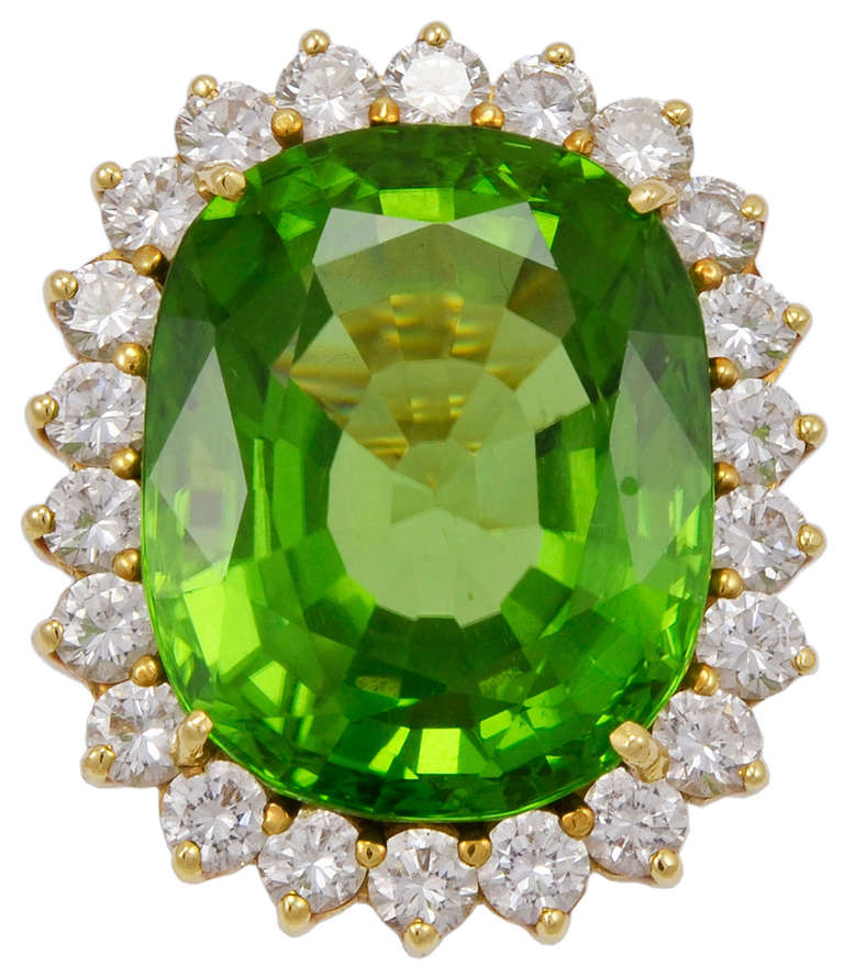 Fabulous striking large peridot cocktail ring set in 18k gold.
Fine brilliant color.. Faceted peridot weighs 20cts surrounded by 1 1/2cts of full cut luminious diamonds. Spectacular look. A dramatic, outstanding piece of fine jewelry. Size 51/2 and