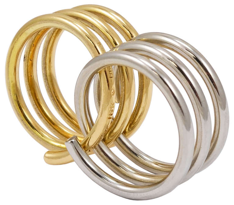 Elegant 18K gold ring, signed and made by Dinh Van, comprised of two interlocking rings, one yellow and one white.

A chic, modern piece of jewelry. Size 5 3/4.
