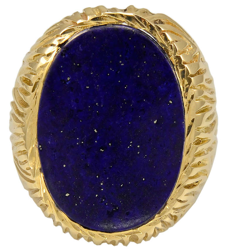 Very striking  men's ring. Large oval lapis, with a lot of gold, set in 14k gold textured setting. Size 11 and may be sized. A bold look; very impressive.