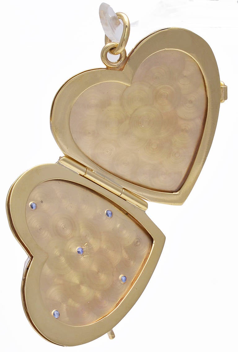 Lovely figural heart locket, 14K yellow gold with sparkling sapphires set in star design. Opens to hold two pictures. Satin finish gold on top and shiny gold on back, suitable for engraving.