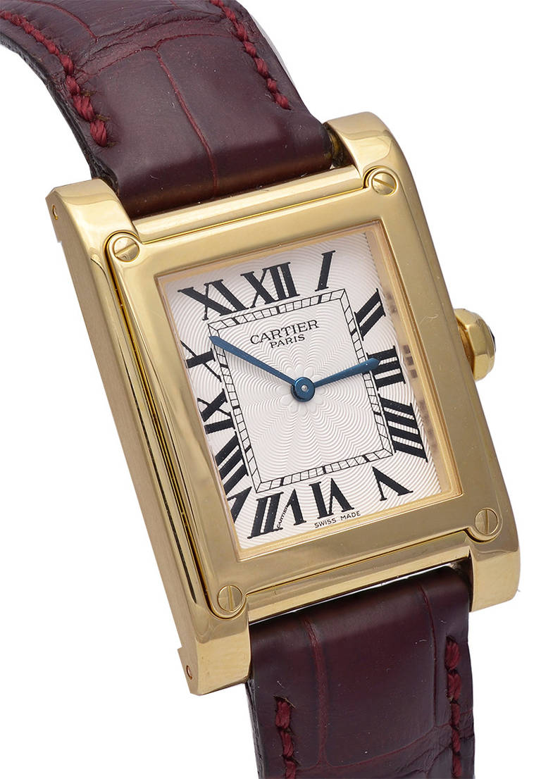 Cartier 18K yellow gold Tank a Vis wristwatch, 27x31mm case. 
This Cartier model features a guilloche silvered dial and a manual-wind movement. With an 18k yellow gold deployant buckle.