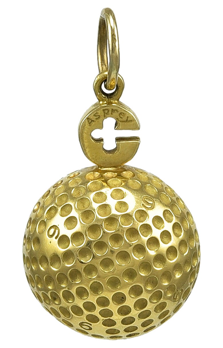 Large figural golf ball pendant/charm.  Made and signed by ASPREY.  18K yellow gold.  Solid.  Engraved 