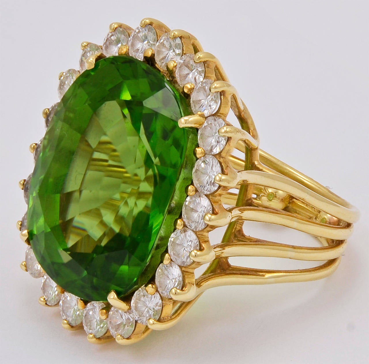 Peridot on a grand scale. 20cts. of glorious color peridot surrounded by dazzling white diamonds, in a beautiful 18k gold setting. This is a showstopper, extraordinary in every way. Size 5 1/2 and may be easily sized.