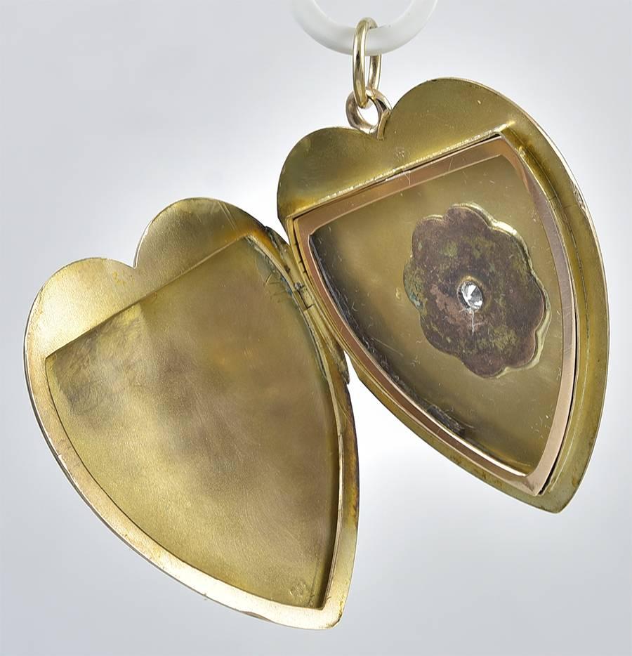 Big & beautiful figural heart locket. Set with a center diamond surrounded by a radiant star. Opens to hold one picture. 14K mellow yellow gold. 1-1/2