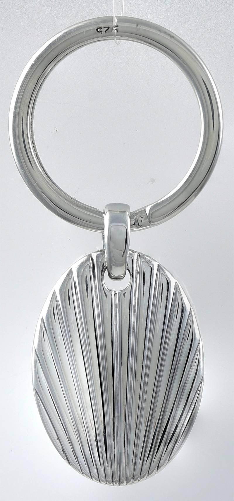 Outstanding quality key ring. Made & signed by Cartier. Very solid and heavy gauge silver. The oval drop has deeply engraved deco lines, front and back. Accented with an applied lapis stone in a bezel. The key ring itself is also sterling. Feels