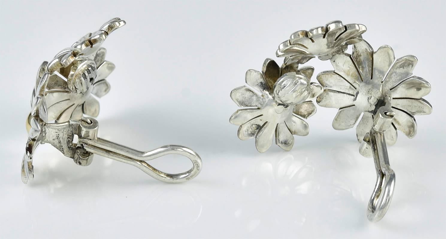 Very attractive ear clips, made and signed by GUCCI.   Figural sterling silver daisies, set with 18K gold centers.   The earrings have a 
