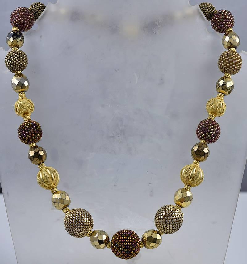 Beautiful handmade and hand-beaded necklace in antique glass and crystal.  Made by AXEL RUSSMEYER.  Crystal beads in bronze, copper, rainbow and graphite.  14K yellow gold magnetic closure.  There are four 14K gold balls interspersed with the beads.