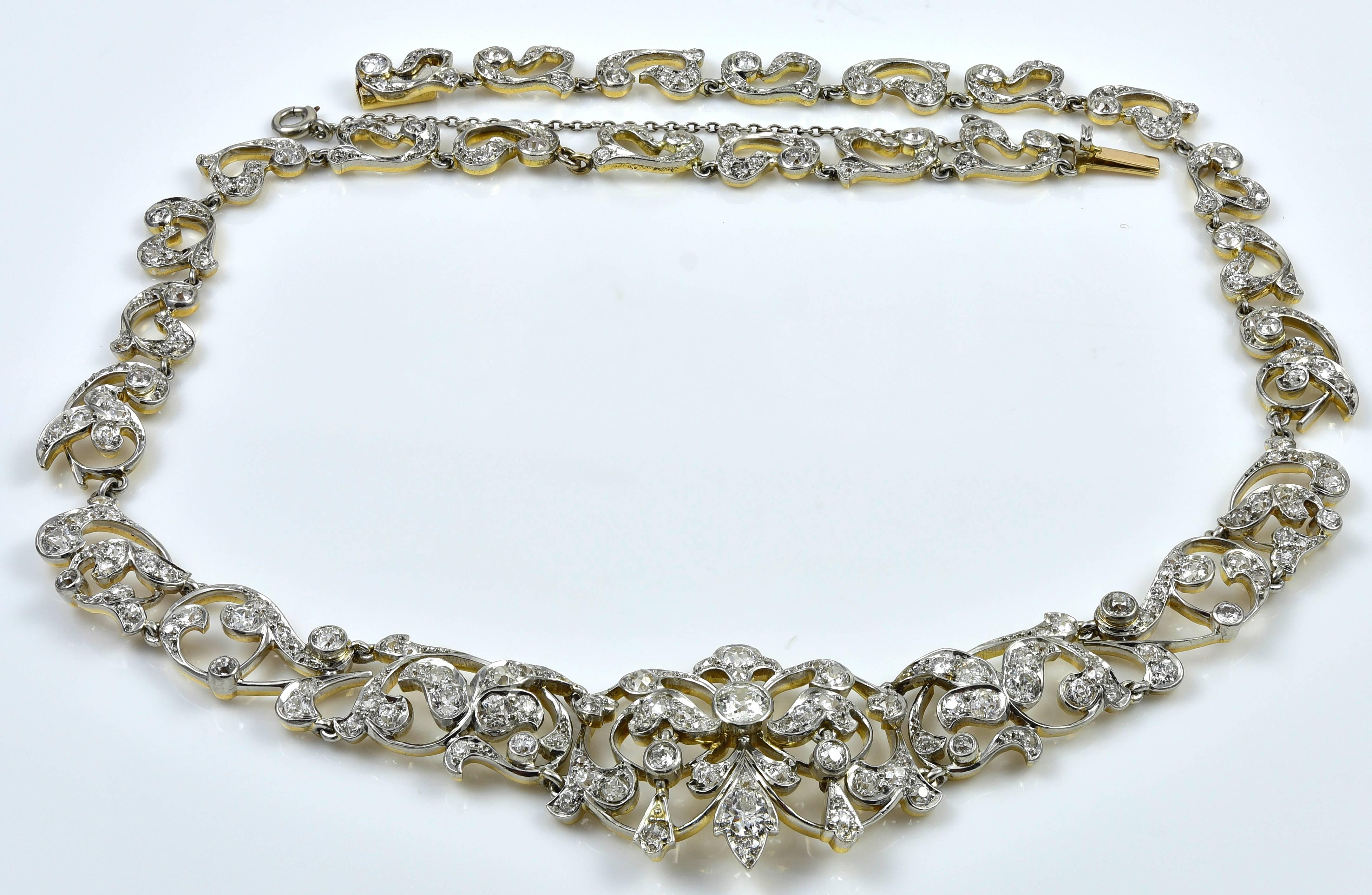 Luminous Edwardian diamond necklace.  Platinum and 14K yellow gold.  All around open work rosette and leaf pattern.  Approximately 7.50 carats of beautiful old mine cut diamonds, G-H color.  Mixed prong and bezel set.  15.