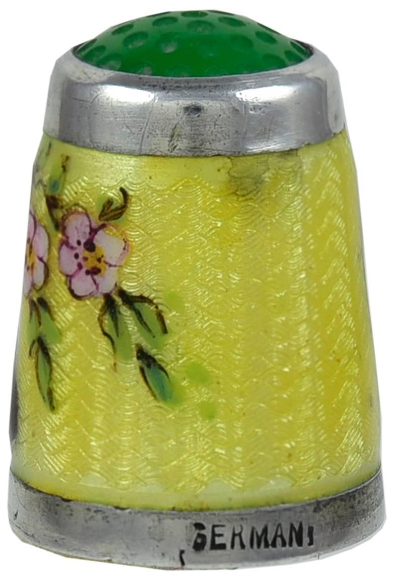 Sterling silver thimble with yellow enamel decoration .  Two black and white cats holding paws, surrounded by  enamel pink roses. Green glass top.  A perfect gift for a feline fancier or for a thimble collector.

Alice Kwartler has sold the finest