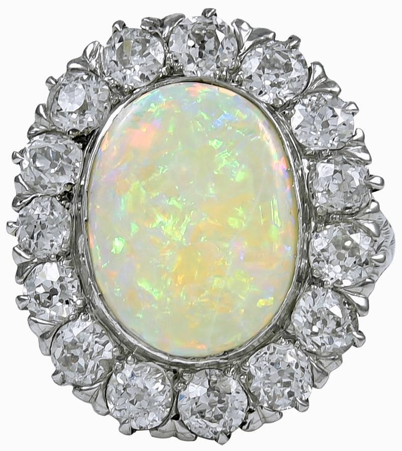 Gorgeous large opal ring. The opal, approximately 5 cts., has fiery color and is extremely lustous.  It displays pink, blue, orange, green and red colors, with a dramatic play of light.  It is surrounded by 6.50  cts. of brilliant white diamonds. 