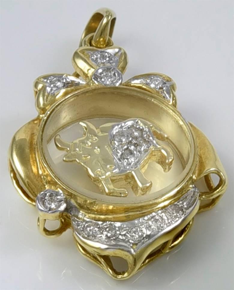 Wonderful Taurus charm.  18K yellow gold frame; clear glass center, with a diamond-encrusted bull that spins around as you move.  1