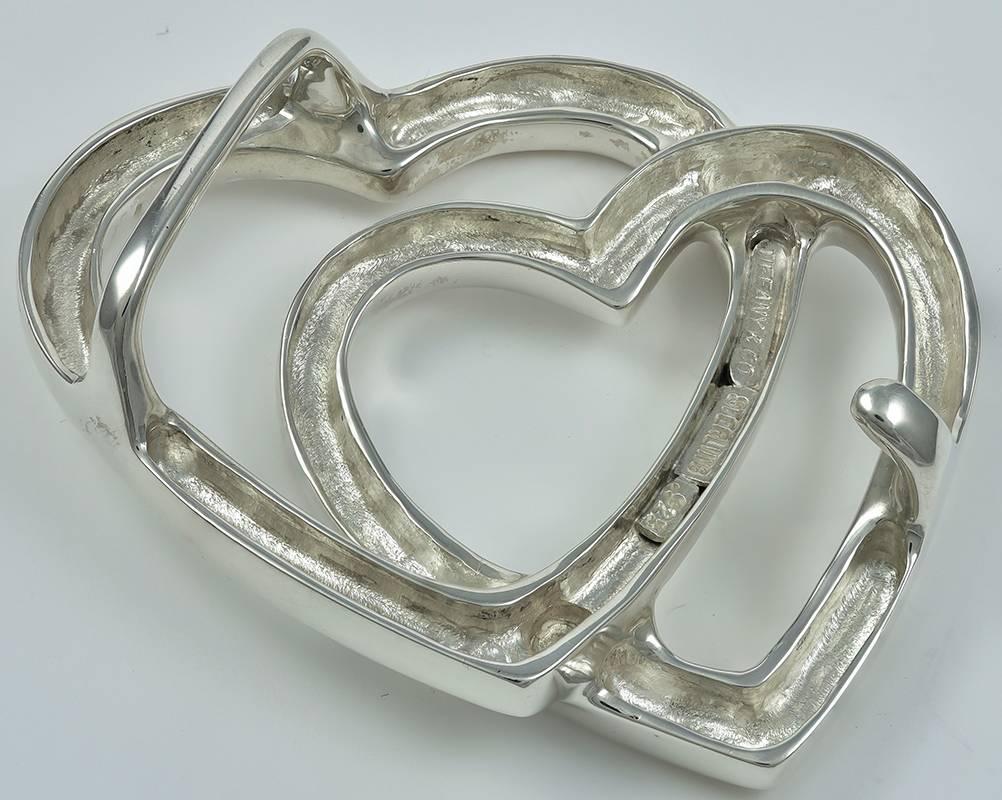 Large figural intertwined double heart belt buckle.  Made and signed by TIFFANY & CO. Heavy gauge sterling silver.  2 1/2