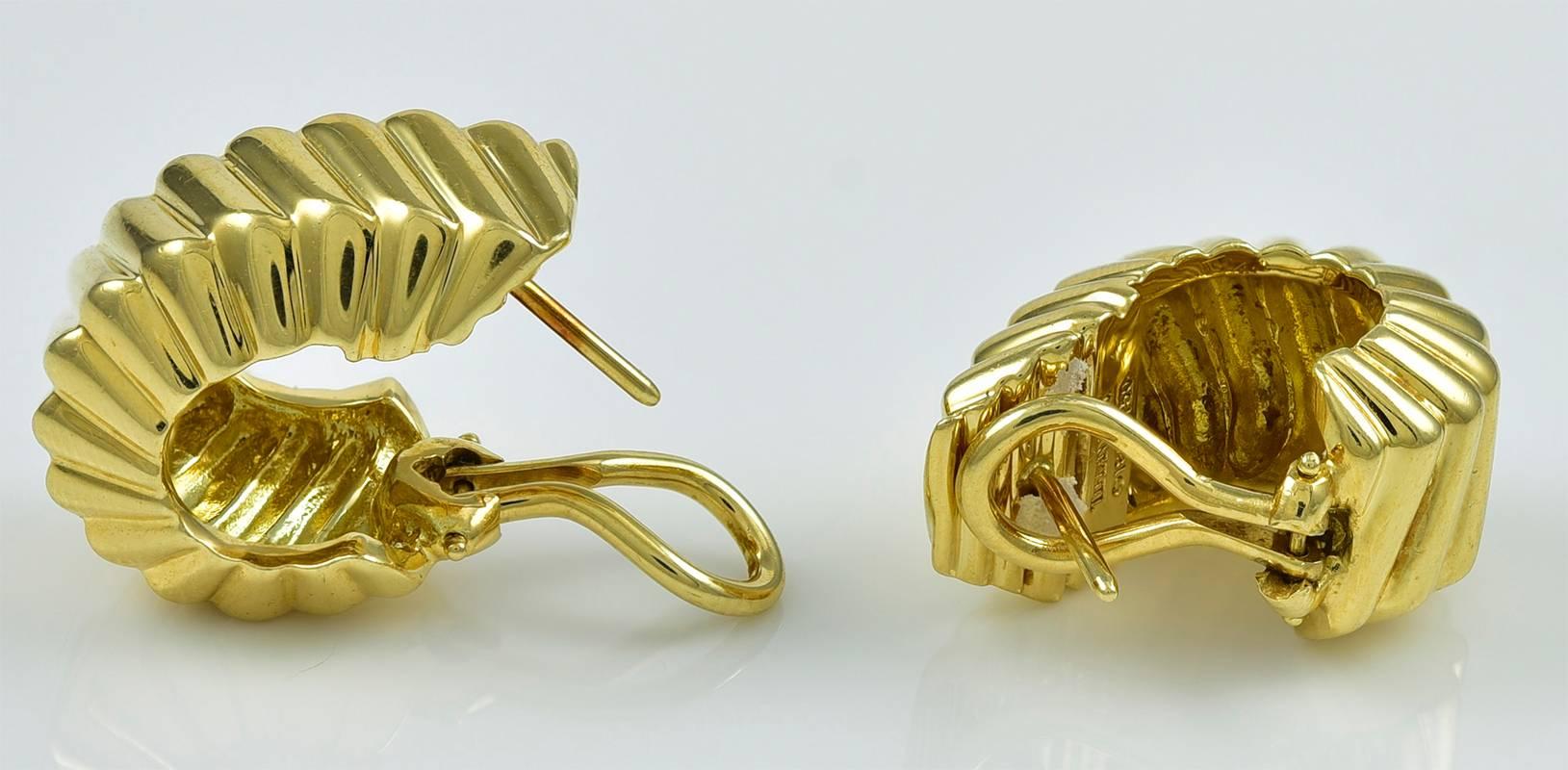 Very attractive 18K yellow gold ear clips  Made and signed by TIFFANY & CO.  18K yellow heavy gauge gold.  Beveled on front, back and sides.  Allover diagonal ribbed pattern.  Omega clips with posts.  7/8