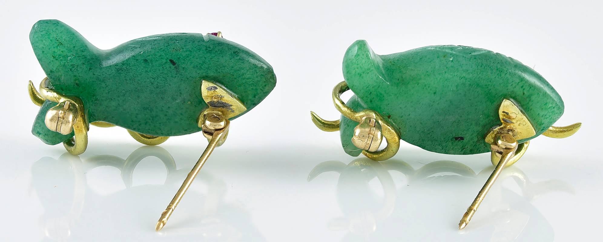 Adorable pair of figural fish pins.  The fish are carved jadeite, with faceted ruby eyes, swimming in an 18K yellow gold ocean.  1 1/4