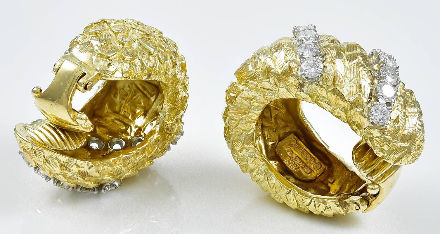 Striking earrings, made and signed by DAVID WEBB.  18K textured gold, in a raised diagonal line pattern. Set with two rows of brilliant diamonds.  Spring tension closure, with grooved lines for added comfort and security.    1 1/4" x 1/2."