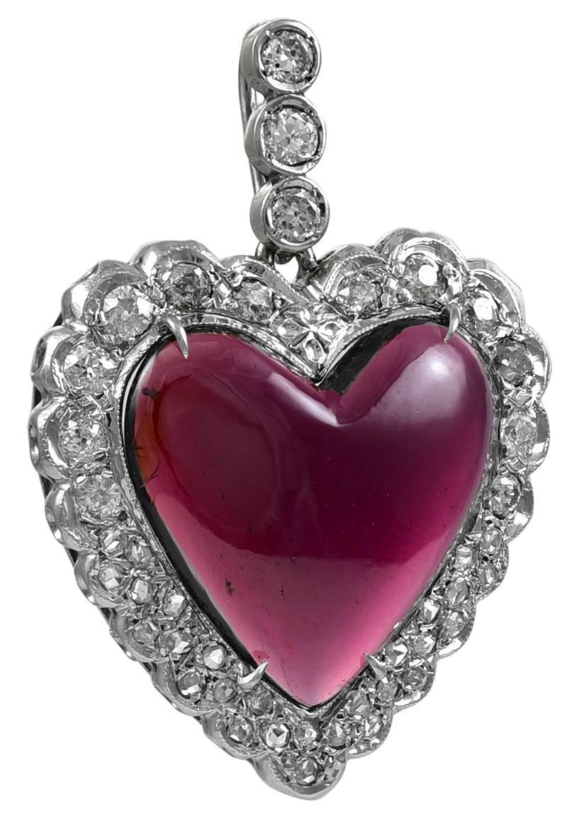 The ultimate romantic valentine gift:  a figural "heart" pendant.  A luminous garnet (approximately 8 cts.) surrounded by brilliant diamonds (1.25 cts.), with a triple diamond bail.  14K white gold.  1 1/2"  x 1."   Absolutely