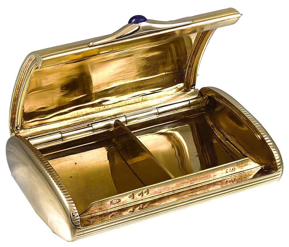 Boîte à pilules exceptionnelle avec un séparateur doré pour aider à séparer les pilules.  Or jaune 18 carats très épais.  Fermeture en saphir cabochon.  Le dessus et le dessous présentent un motif de lignes gravées ; les côtés sont en or brillant. 