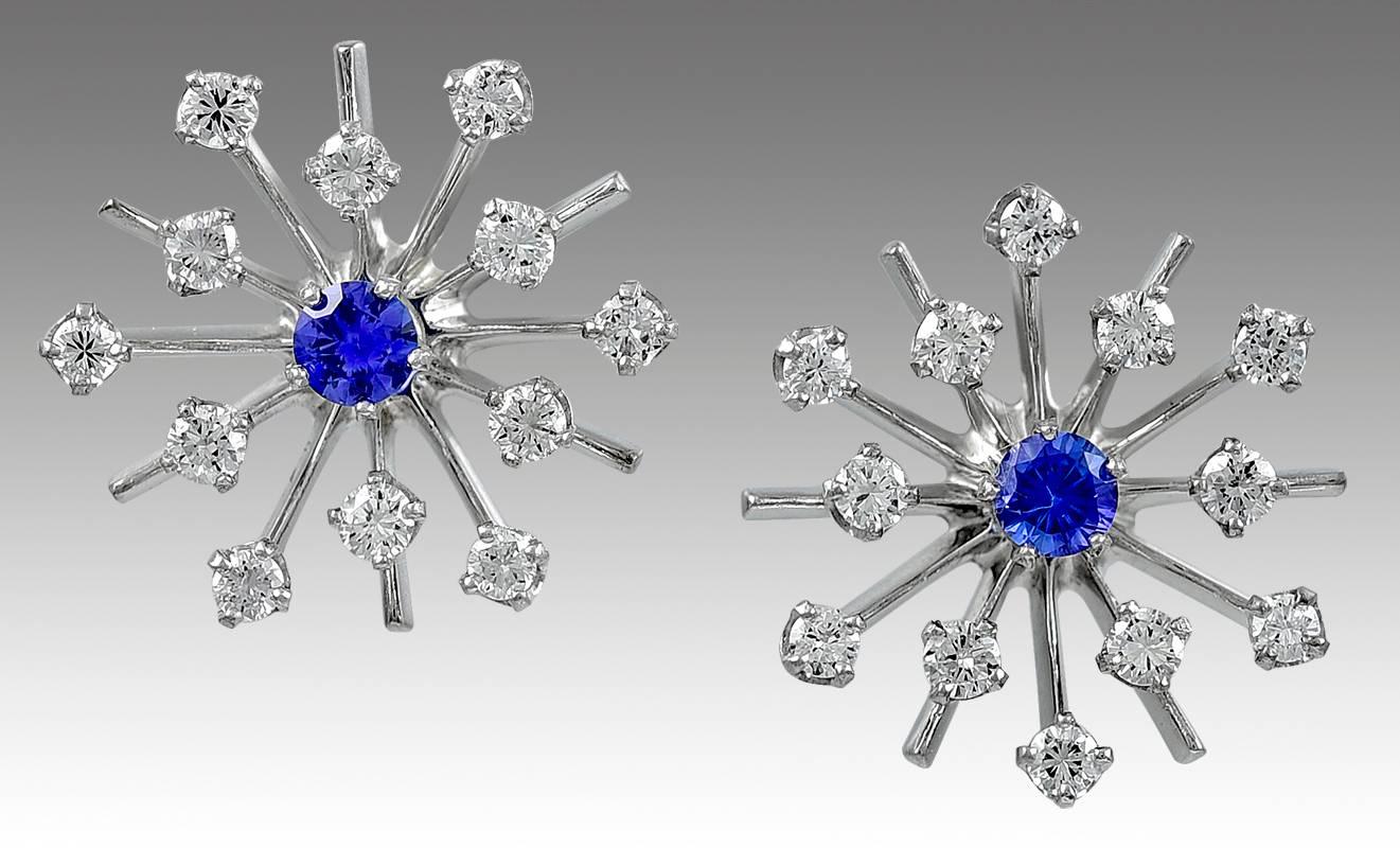 Sparkling starburst earrings, set with twenty four faceted diamonds approximately 1.25 cts. and centered with bright sapphires approximately 0.50cts. 14K white gold.  Post backing.  3/4" in diameter. A very pretty, festive look.
  
Alice
