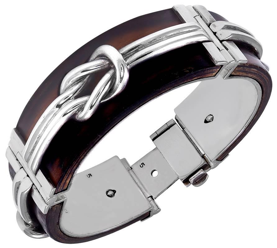 Striking and unusual bracelet.  Made and signed by GUCCI.  Comprised of three curved ebony segments, with applied sterling silver decoration.  The reverse side is riveted to the front and is heavy gauge sterling silver.  Very firm closure, with