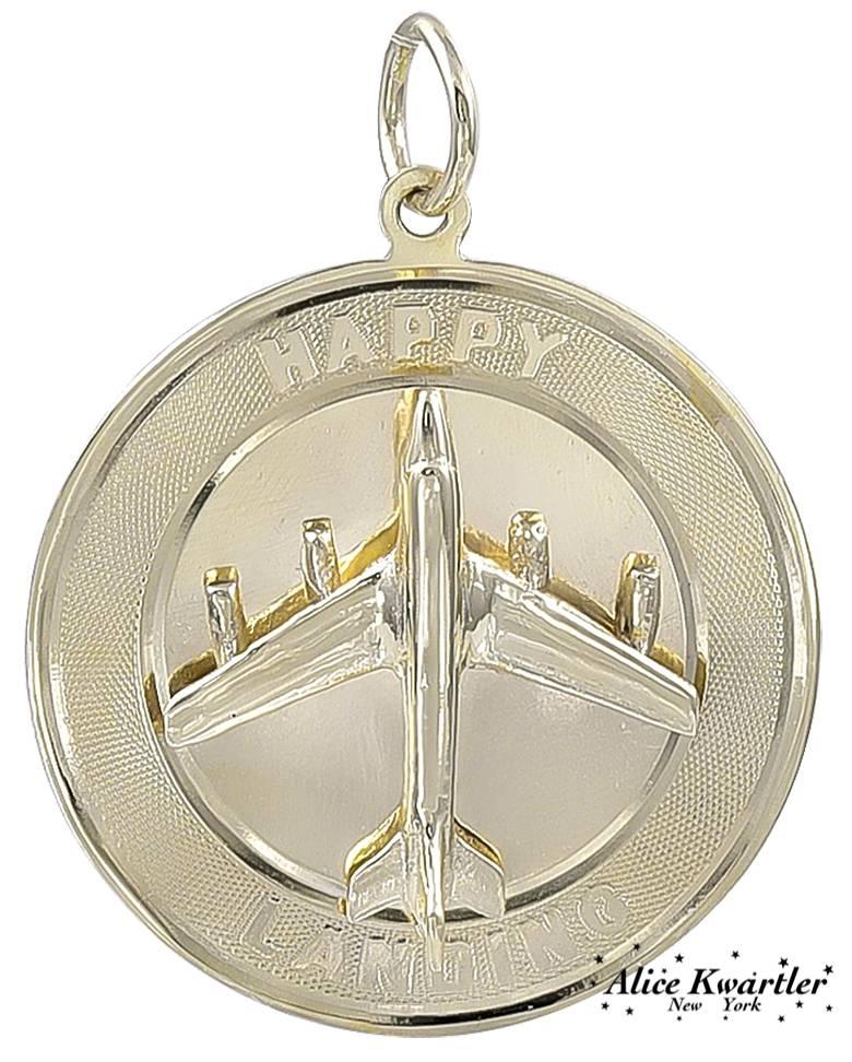 A wonderful travel charm:  a figural "jet plane" is applied to the center.  Around the engine-turned border is the message "HAPPY LANDING."  1" in diameter.  14K yellow gold.  A talisman for the world traveler.

Alice