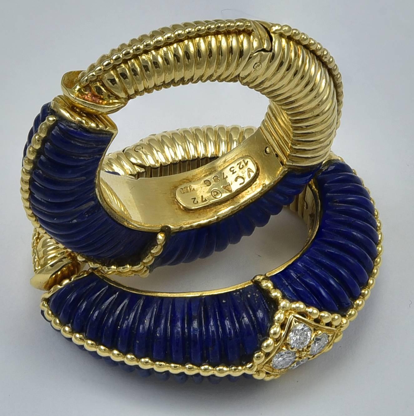 Large and dramatic carved lapis hoop earrings. Made, signed and numbered by Van Cleef & Arpels. 18K yellow gold with ribbed pattern that matches the carving on the lapis. Each earring is set with four round brilliant full-cut diamonds. 1-1/2
