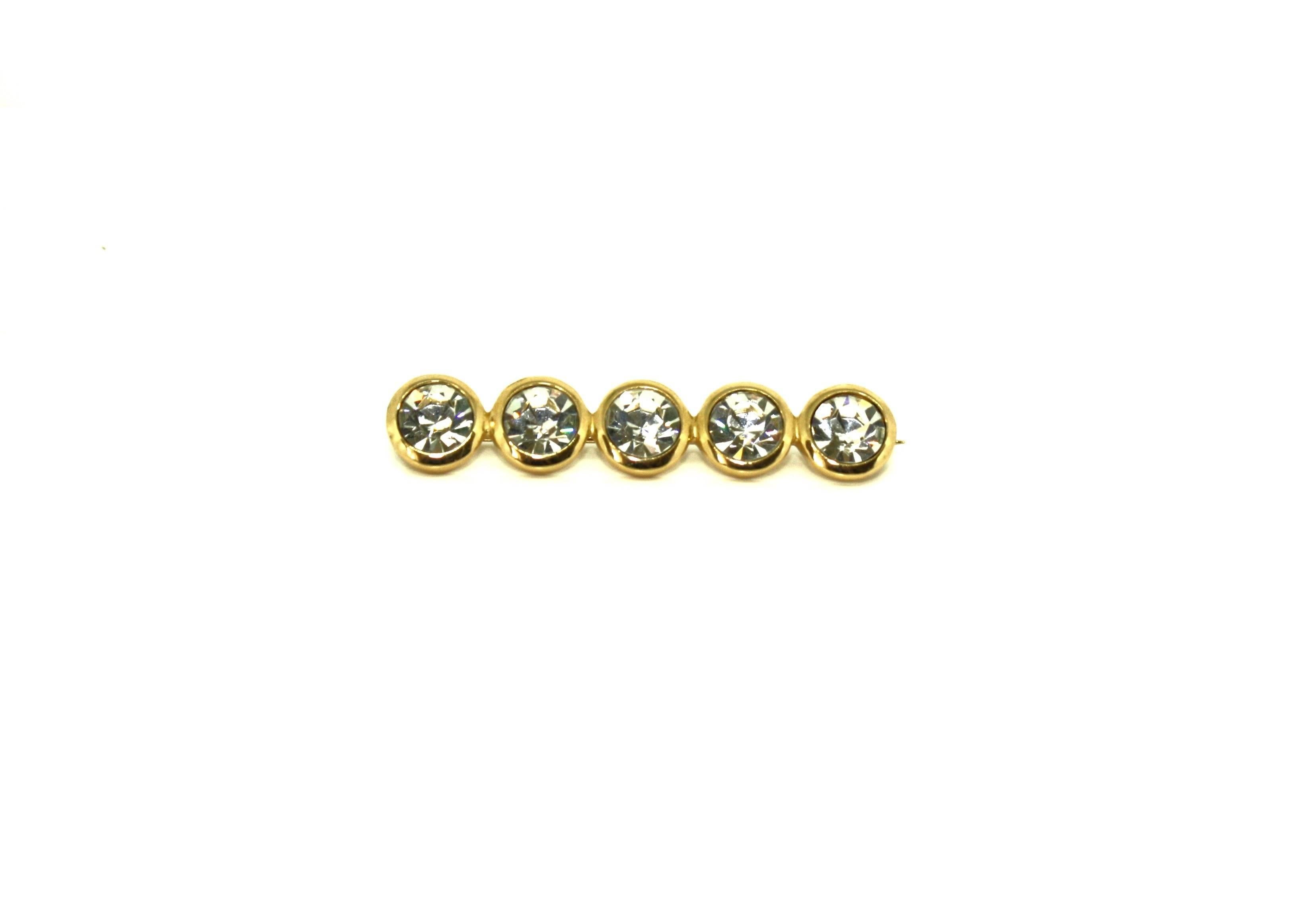 Five dazzling white faceted stones are set into gold plated base metal to make up this simple yet elegant brooch by Christian Dior. Each stone measures approximately 1cm in diameter. This brooch has been dated to the late 1980's and is marked with