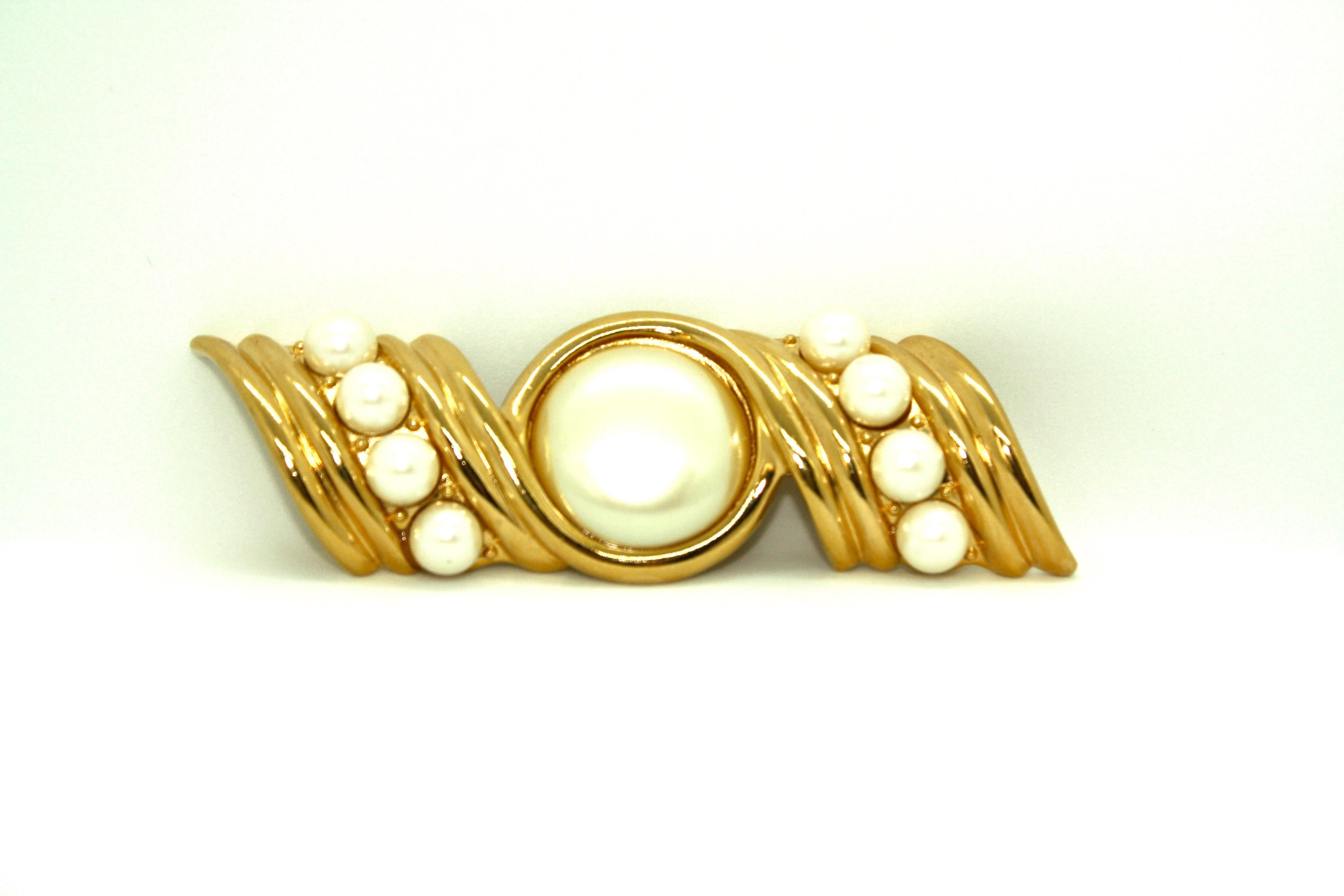 Huge statement brooch from the 1980's by Yves St Laurent, featuring a mix of pearls and textured gold plated metal. The reverse of the brooch features the YSL logo and also features the 'Radiant' back, introduced to YSL jewellery made by American