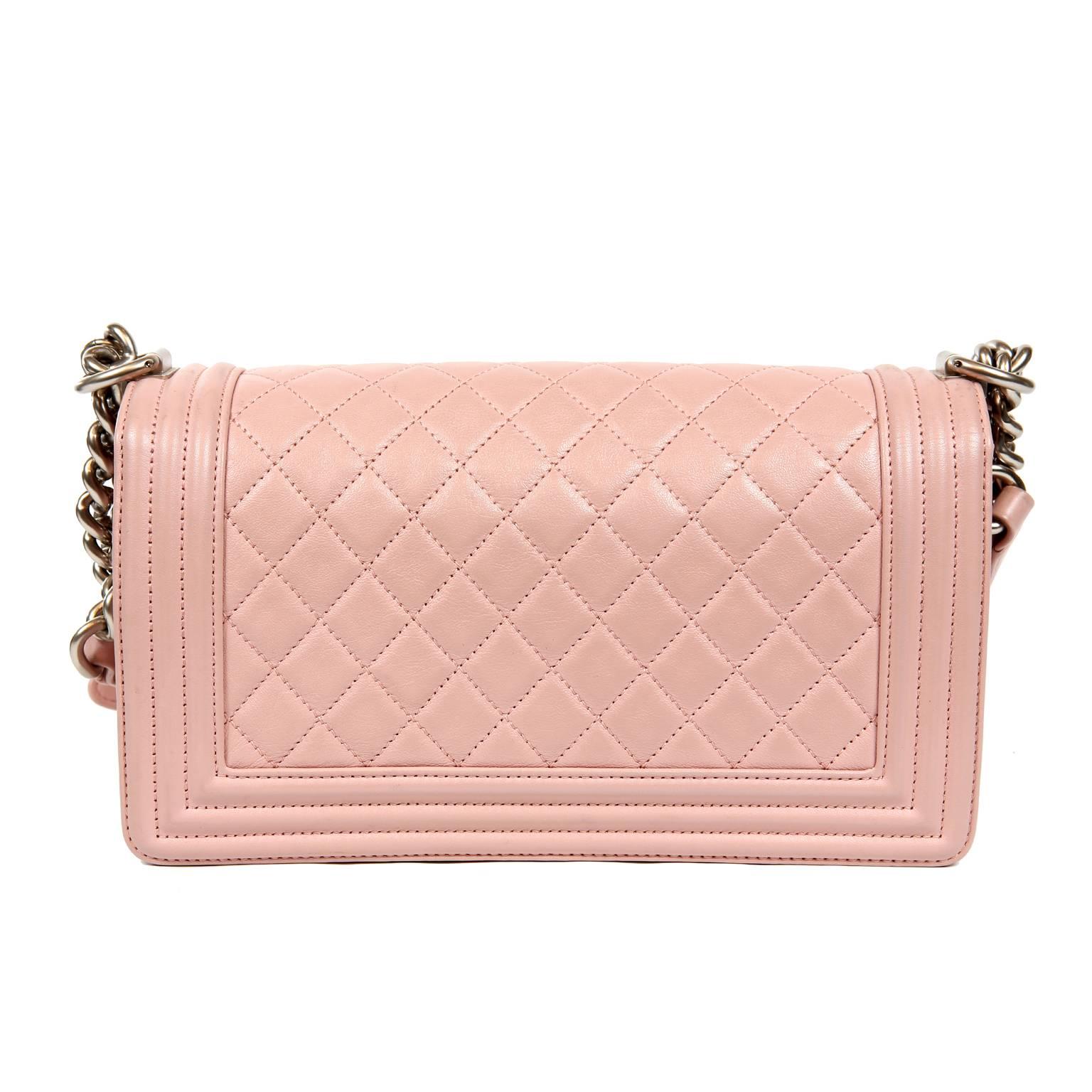 This authentic Chanel Pink Leather Medium Boy Bag is pristine; never before carried.     The updated design is structured and edgy with a versatility that makes it extremely popular.  
Ballerina pink leather is quilted in signature Chanel diamond