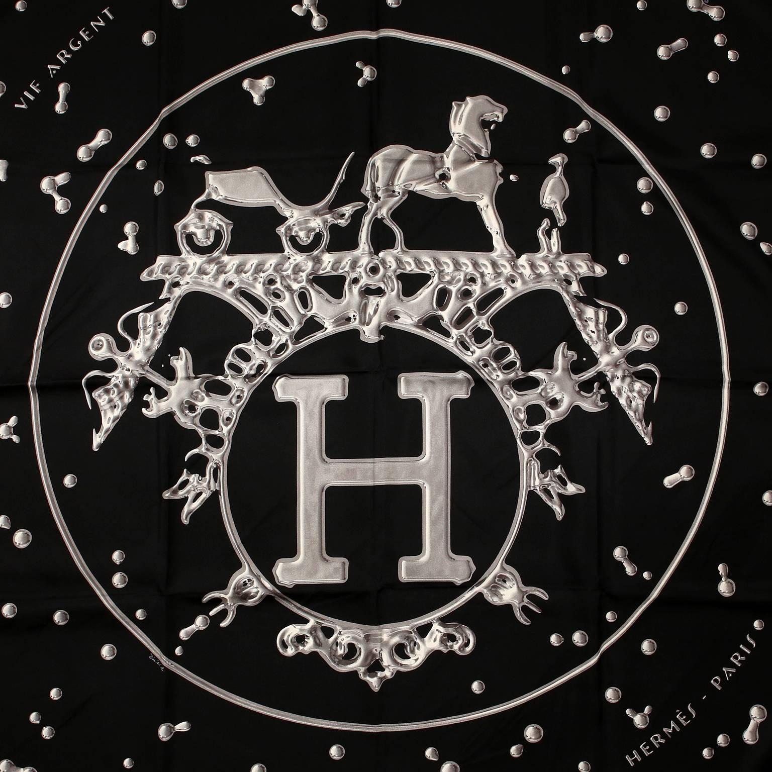Hermès Black VIF Argent 90 cm Silk Scarf- PRISTINE
Designed by Dimitri Rybaltchenko and first issued in 2007. 
Black background with Hermès signature H and horse drawn carriage logo in silvery liquid mercury.  Striking and dramatic.  100% silk.  36”