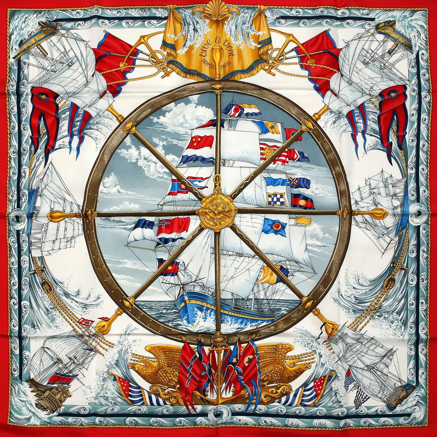 Hermès Vive le Vent 90 cm Silk Scarf- PRISTINE
Designed by Laurence Bourthoumieux and first issued in 1992.
White background with red border and gold accents.  Nautical theme with sailing ships and waving multicolored flags.  100% silk.  Made in