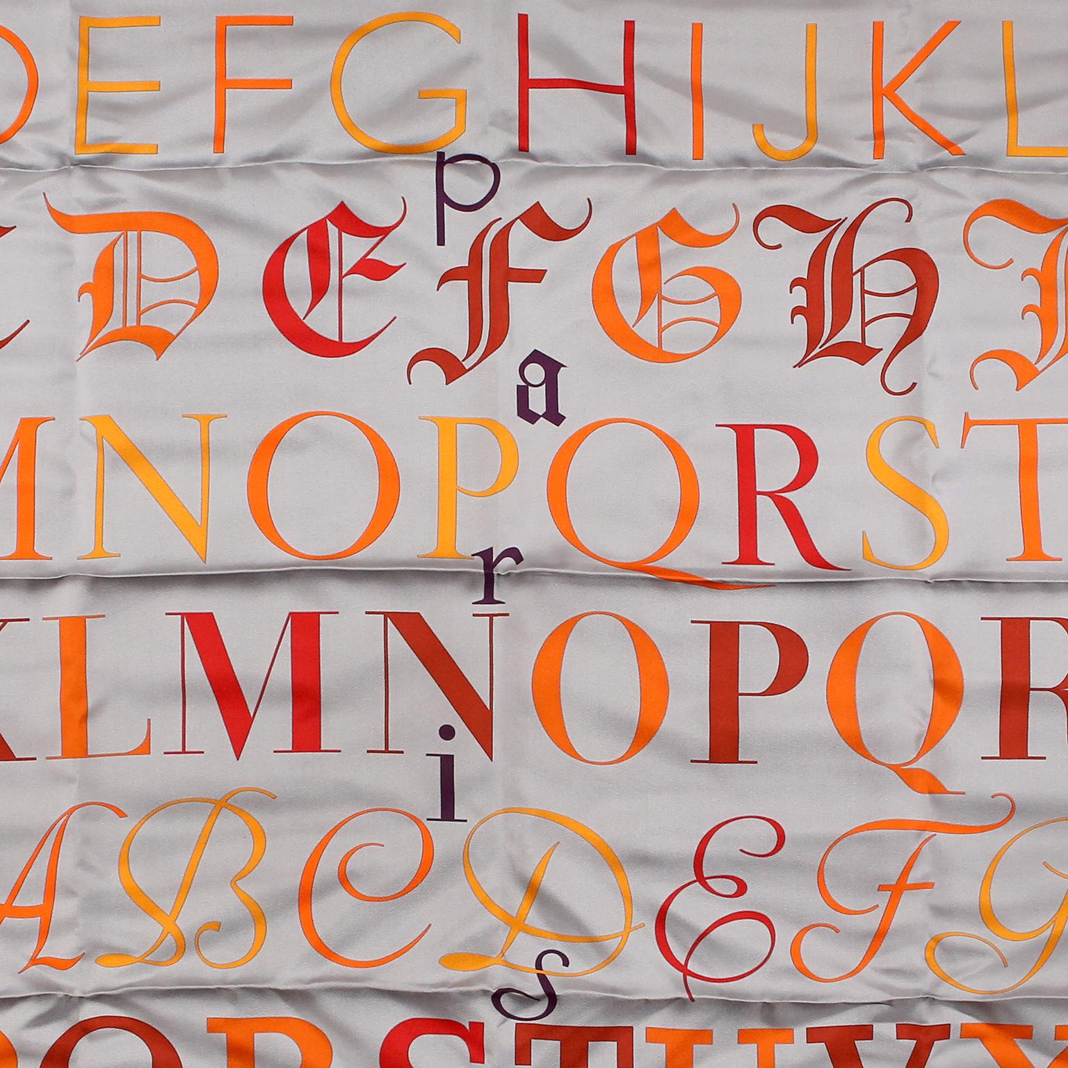 Hermès Grey Litterature 90 cm Silk Scarf- New with box
Silver grey background with letters of the alphabet in shades of red, orange and yellow.  By A.  M.  Cassandre for Hermès.  Made in France.  100% silk.
35