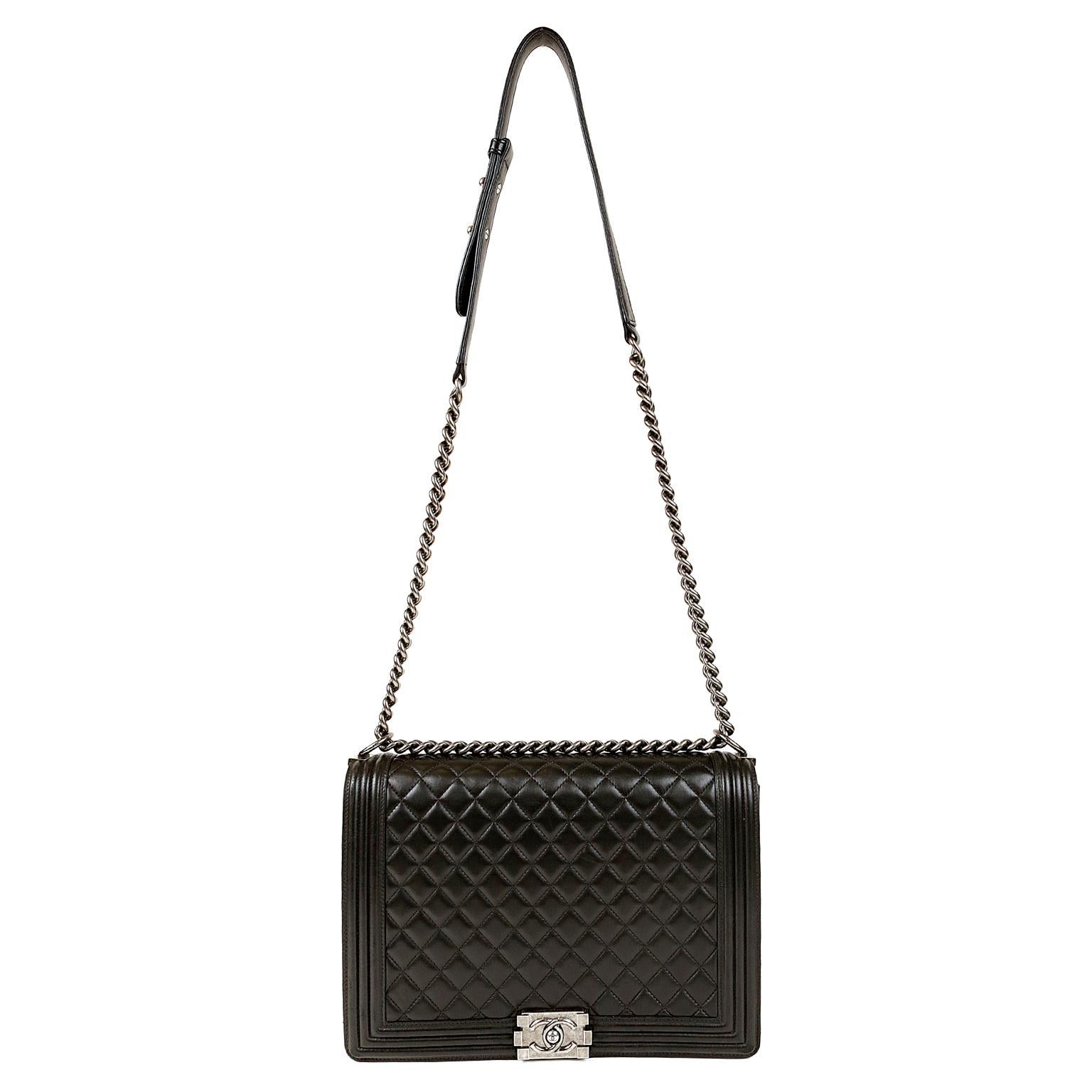 Chanel Black Lambskin Large Boy Bag- PRISTINE; appears never carried.     
The updated design is structured and edgy with a versatility that makes it extremely popular.  
Black lambskin is quilted in signature Chanel diamond stitched pattern.  Boy