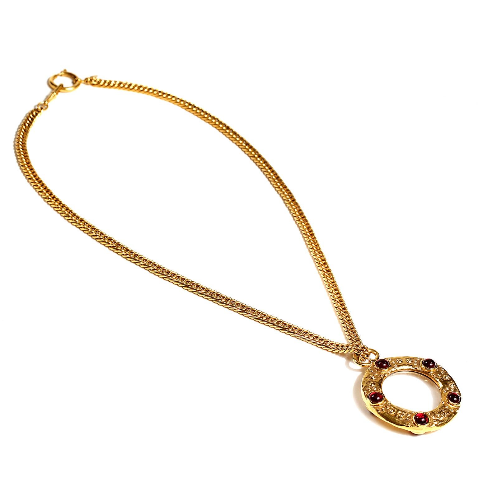 Chanel Gripoix Monocle Necklace - excellent condition
  A rare piece from the 1980’s, it is brilliant addition to any collection. 
Gold tone large medallion with Gripoix dark red glass stones.  Long gold tone linked chain with spring ring clasp. Box