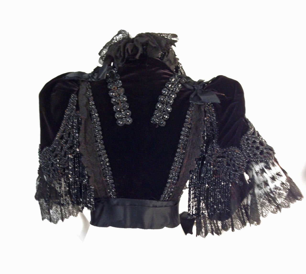 House of Worth, the famous Victorian couturier house founded by Charles Frederic Worth considered to by some as the “father of couture”, created this 1890's jet beaded capelet.  This capelet is constructed of black silk velvet with a frilly, curly