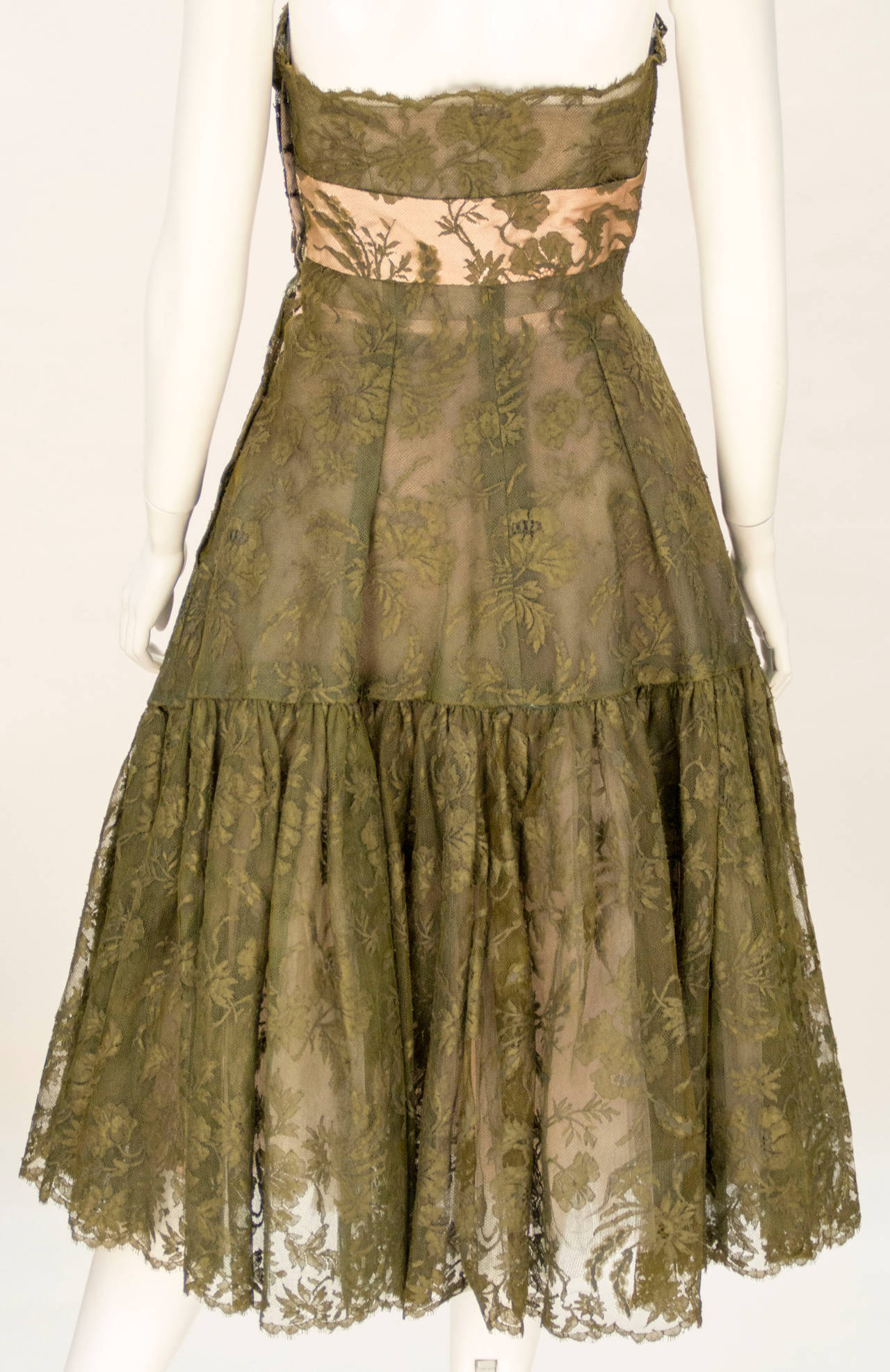 Extremely rare constructed and preserved is this 1950's Lanvin-Castillo designed dress.  With color typically used in the era, an olive green is used brilliantly upon the strapless lace bodice with pink accents.  This is Lanvin design at its finest.