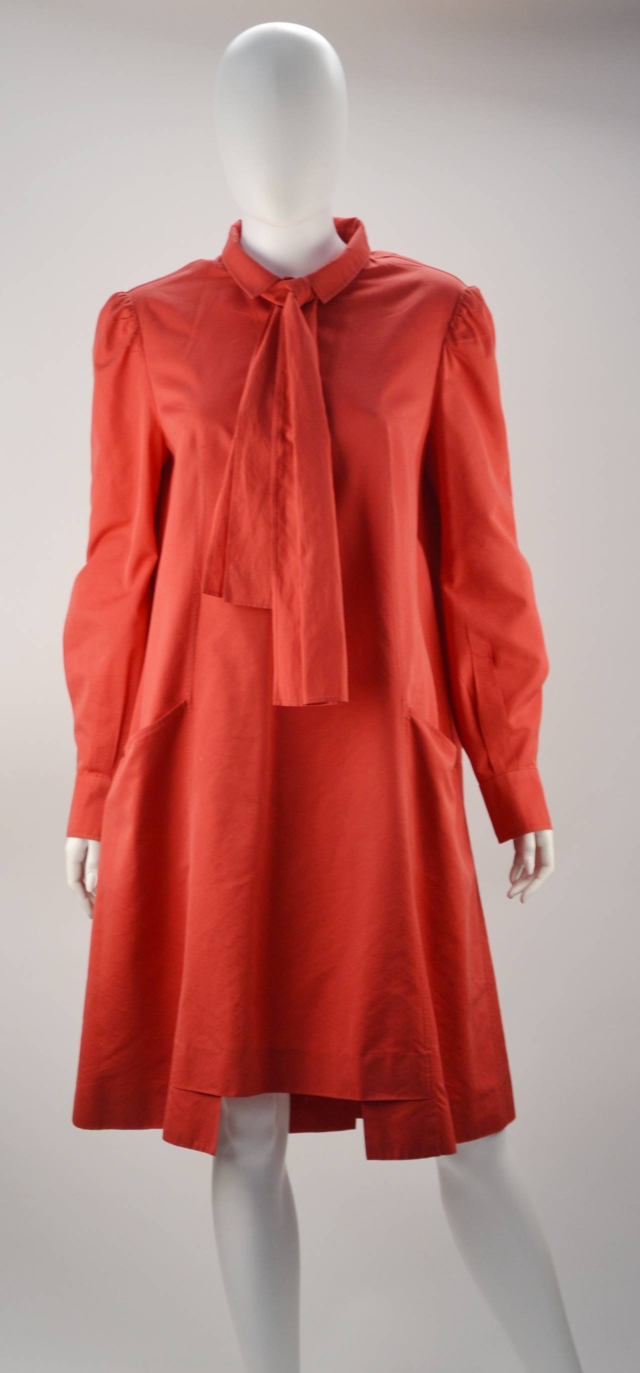 Light and airy red Yves Saint Laurent tent dress.  Can be worn any time of year. We have seen it belted or straight and flowing.  The bishop sleeves can be worn down or rolled up and the tie at neck can be worn many ways.  How about pinning on a