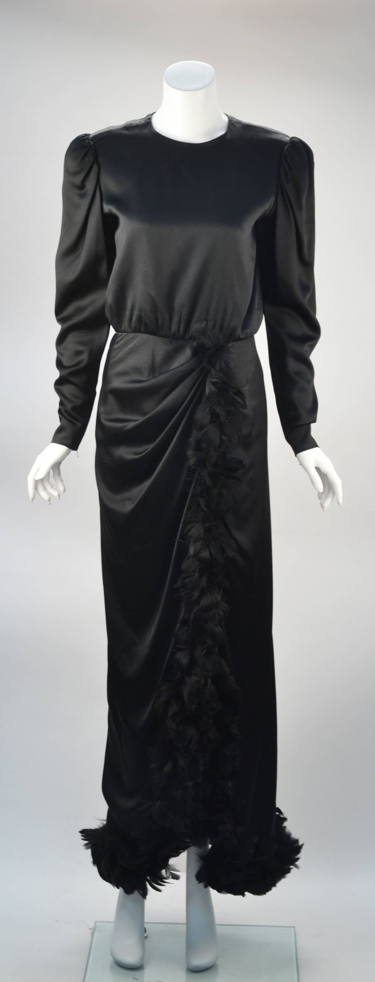 Gorgeously draped 1970’s Givenchy Paris long sleeve silk black gown has luxurious black feathers flowing to and around the hem. Designer puckered shoulder. Zippers at cuffs for perfect fit. Both the puckered sleeves and the feathers create