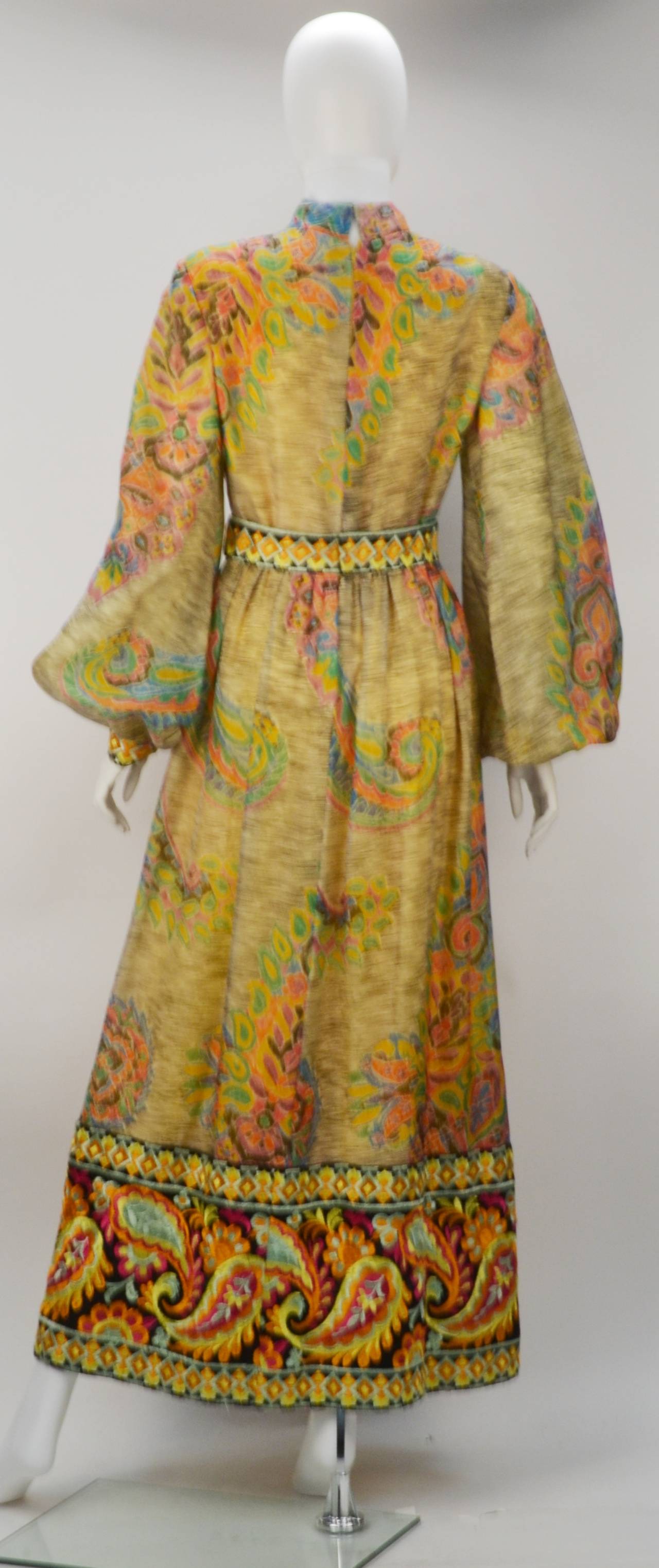 Embrace your whimsy and your accomplished sense of style by wearing this stunning yellow and multi-colored gown. Boho feel with the ornate embroidery in hues of gold and yellow. Its fully embroidered hem, high collar and bishop sleeves makes this