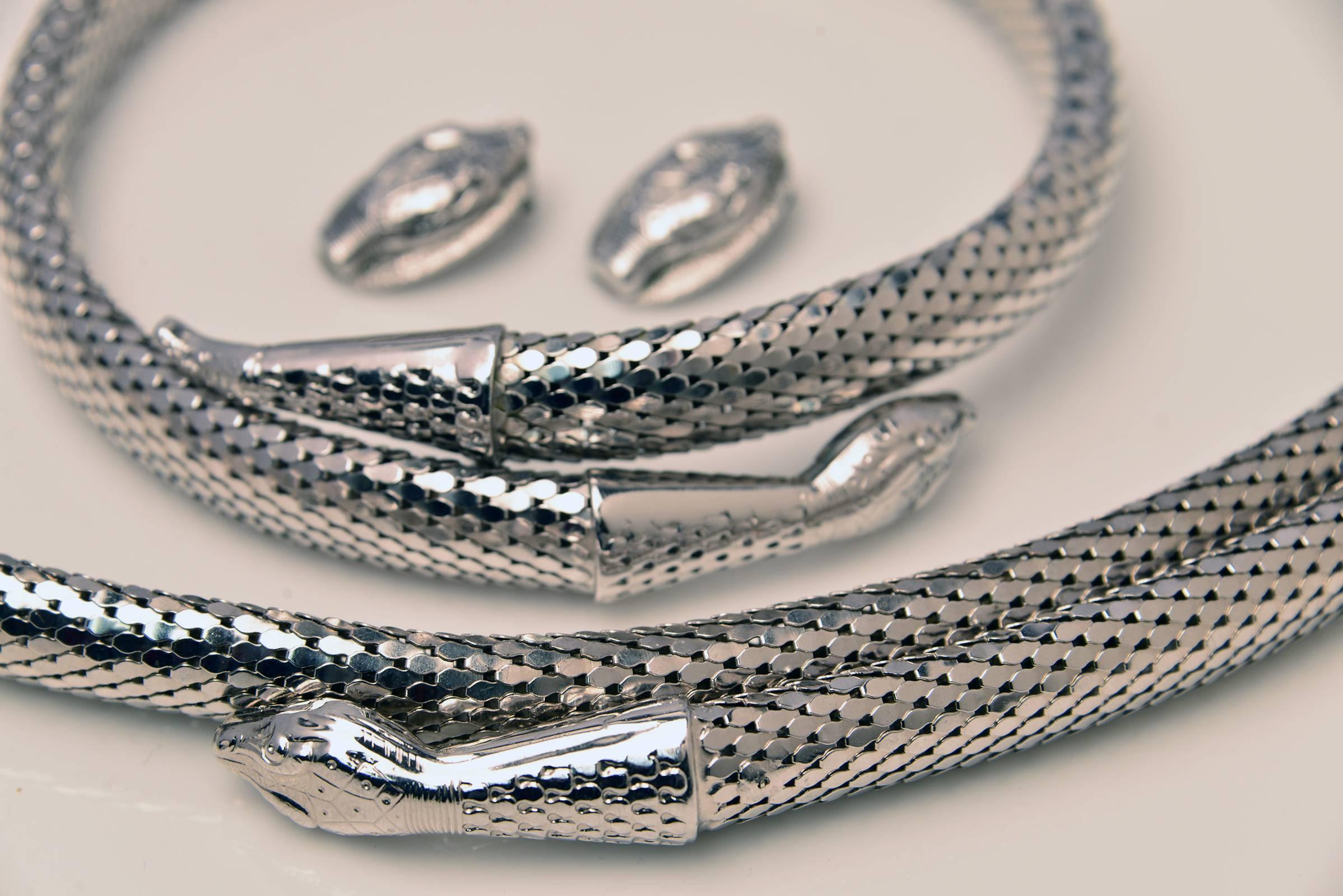 
Wonderful Whiting and Davis Snake coil choker, earrings, and belt are magnificent. Thick, round, weighted silver mesh.  The body is gleaming in silver.  The snake head is engraved in Egyptian inspired style. This style was part of the Cleopatra