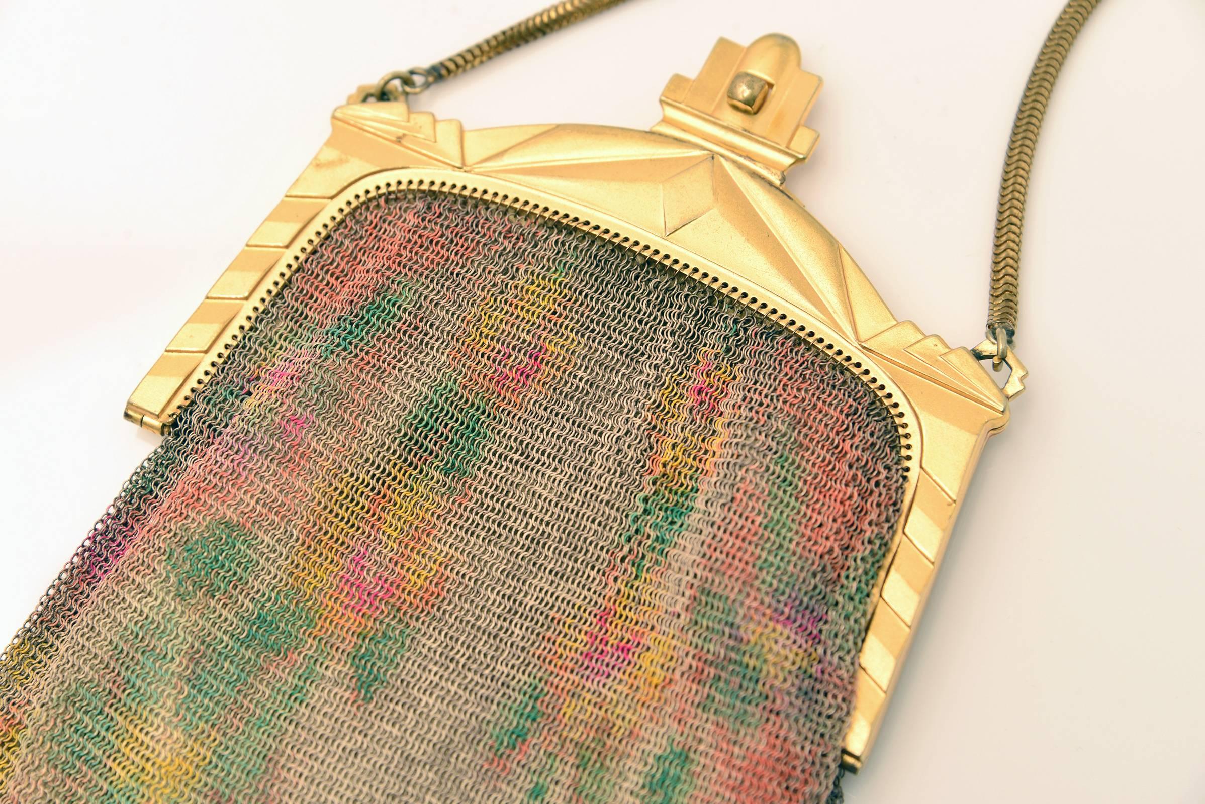 Highly collectible Whiting and Davis mesh purse. This hand bag features painted mesh with an Edwardian/Art Deco frame and a yellow silk satin lining with inside pocket and round gold mirrior. The flower motif is yellow, orange, pink and red on both