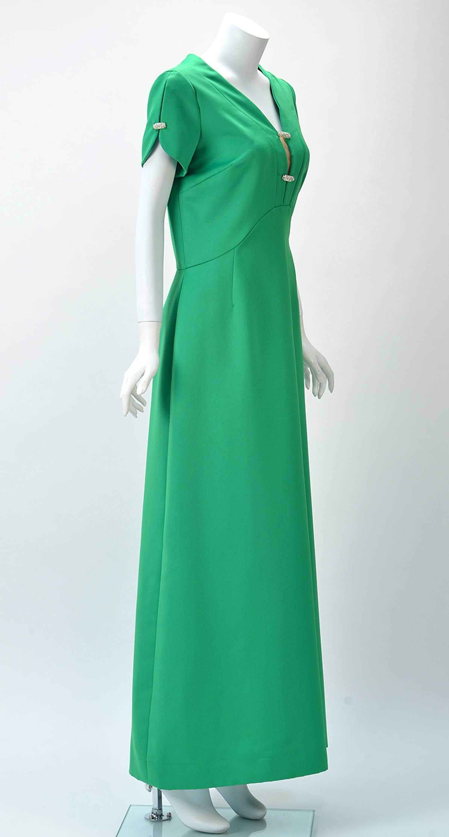 1960's Helen Bass California Kelly Green Party Dress, retailed by Garfinckel's Washington. The bodice and split sleeves feature two silver rhinestone ornaments; with a gentle A - line skirt, with two waist darts. On the back there are four waist