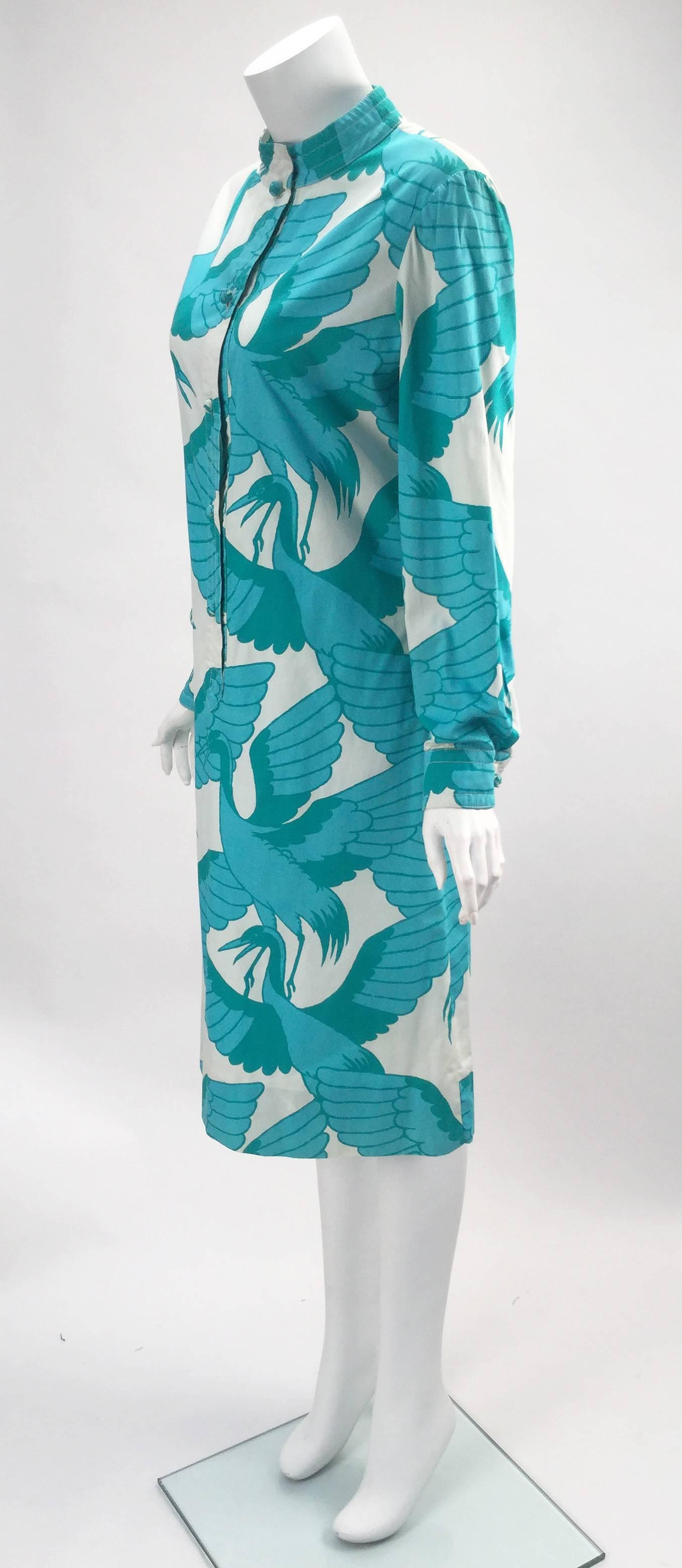 Fantastic 1970s Saks Fifth Avenue cotton knee length shirt dress with blue cranes print made in Thailand.  Placket on center front goes just past the waist and goes up to the mandarin collar. The buttons stop at the waist, cuffs on the long sleeves