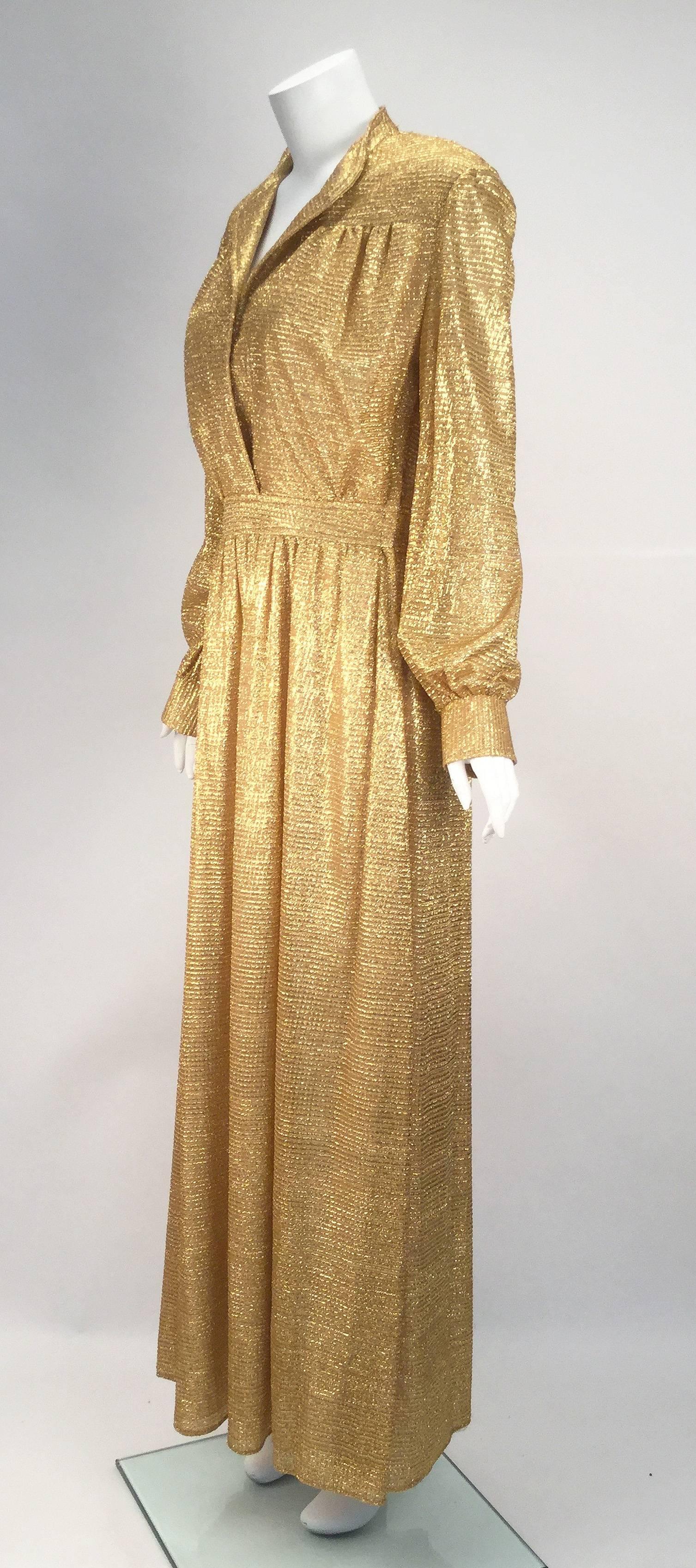 Gorgeous 1970's gold metallic long sleeve maxi dress. Dress up or down, this dress has a stand up collar with center front placket that is open and overlapped down to the waist. Waistband with gathered skirt. Cuffed long sleeves. Bodice and skirt
