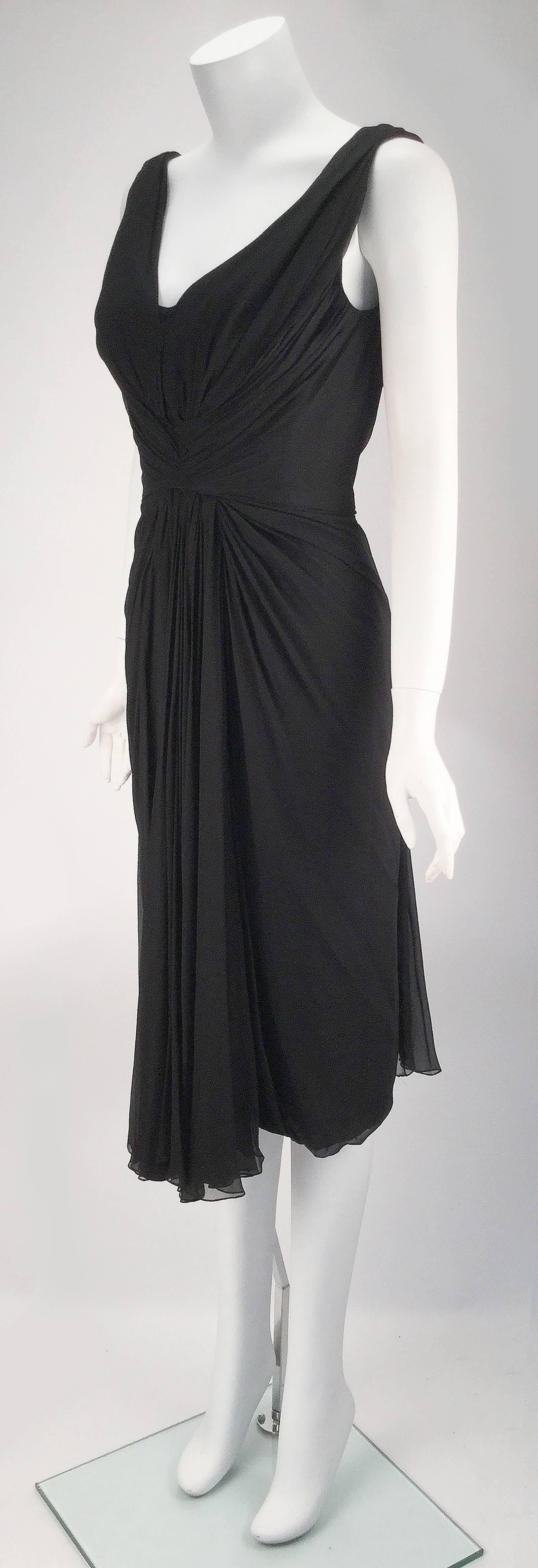 
Uber Lux 1960s Jobere New York black silk sleeveless cocktail dress. Deep V neckline met with gathering at center front. Gathering throughout the straps transition into a low V at center back. Zipper and hook and eye closure at center back. Two