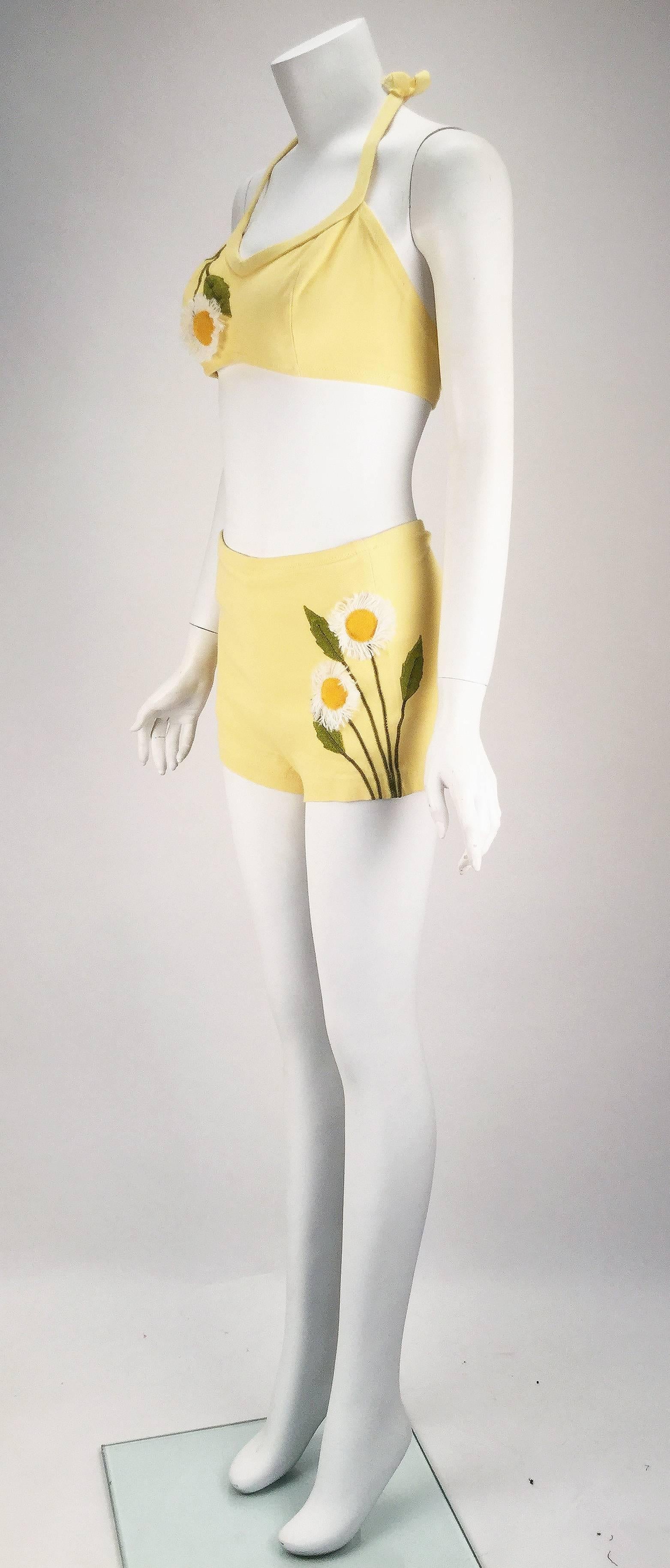 Get ready for a day on the beach while wearing this darling 1950s DeWeese Designs pale yellow bikini with daisy appliques. The bikini top has princess seams and a center front seam. Zig-zag stitch hems. Daisy applique at right bust area. There are